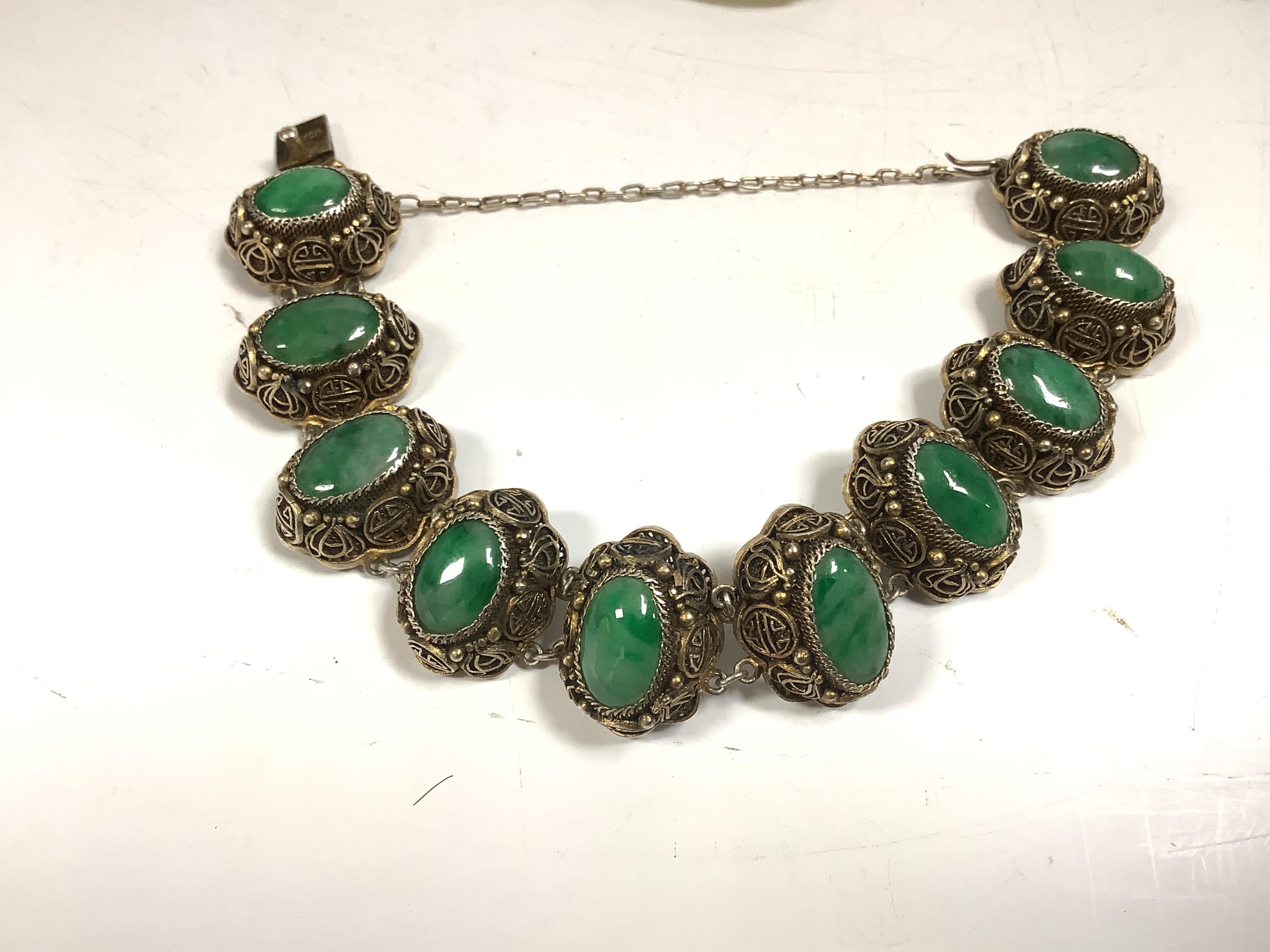 Sixteen Chinese jade and hardstone carvings, including a gilded white metal and jadeite bracelet, three pendants etc. Condition - fair